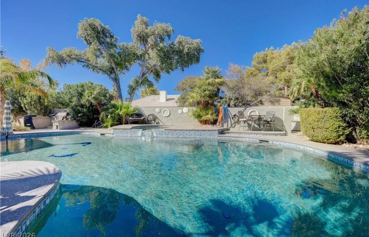 Custom pool with palms behind the home